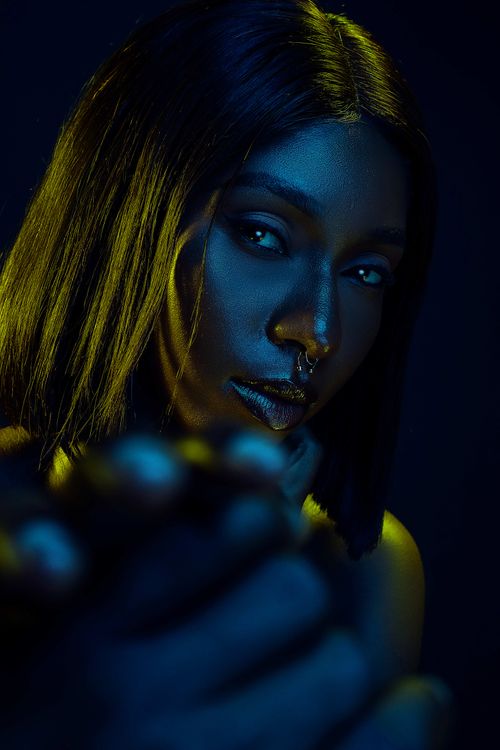 Free Artistic portrait of a woman in studio with dramatic lighting and vibrant colors. Stock Photo