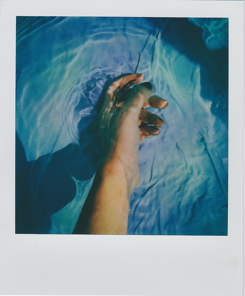 Free A hand gently moves through rippling water creating artistic reflections and refractions. Stock Photo