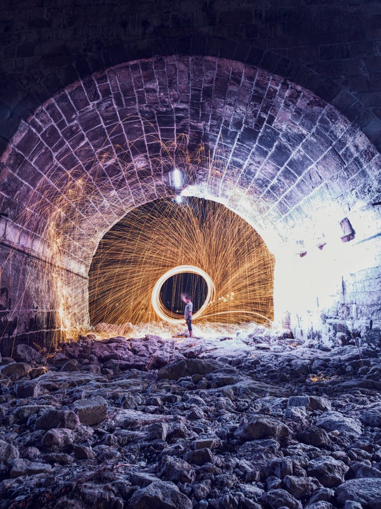 Person Standing In A Tunnel With Fireworks Display