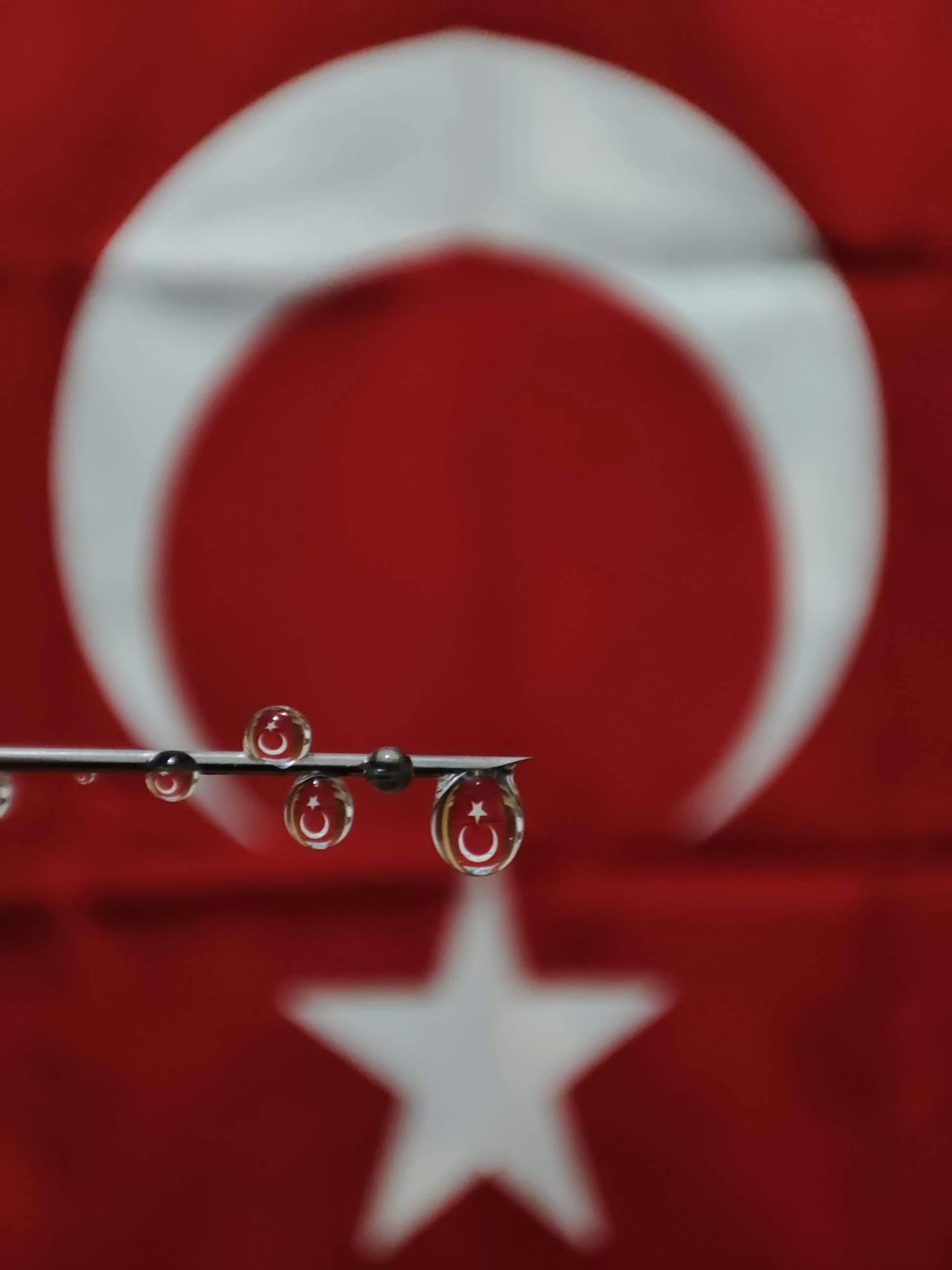 Close-up of water drops reflecting Turkish flag, symbolizing national pride.
