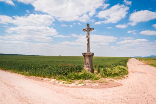 Brown Cross on Brown Dirt Road Under Blue Sky