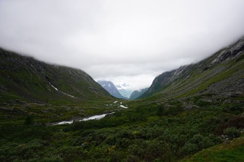 Free A stunning mountain valley with lush greenery and a river under a cloudy sky, perfect for nature enthusiasts. Stock Photo