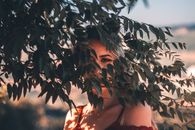 Portrait of a woman partially hidden by leaves in Arruda dos Vinhos, Portugal.