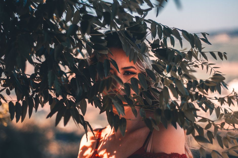 Portrait of a woman partially hidden by leaves in Arruda dos Vinhos, Portugal.