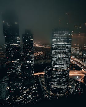 A breathtaking view of the illuminated city skyline at night, showcasing modern skyscrapers.