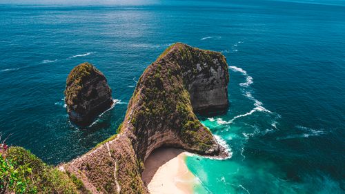 Free Stunning aerial shot of Kelingking Beach on Nusa Penida, Bali, with clear blue sea and dramatic cliffs. Stock Photo