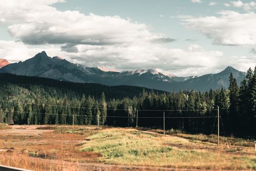 Breathtaking view of the mountain range in Golden, BC, surrounded by lush forests and open meadows.