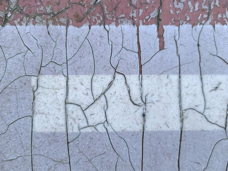 A close-up of a cracked and weathered painted wall in New Taipei City, Taiwan.