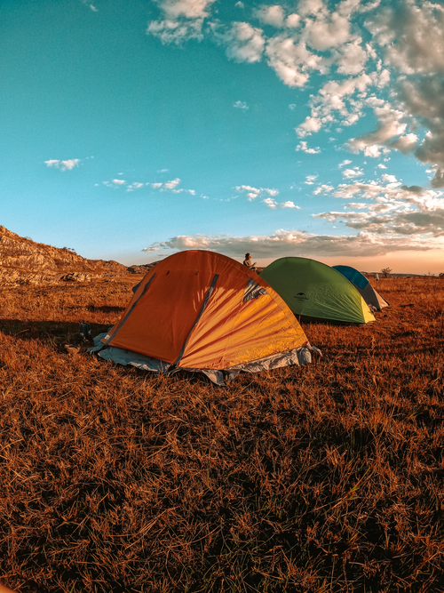 Free Vibrant tents in a scenic field at sunset, capturing the adventure and beauty of Santana de Pirapama. Stock Photo