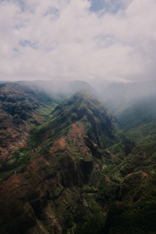 Free A breathtaking view of mist-covered mountains with a lush green valley below. Stock Photo