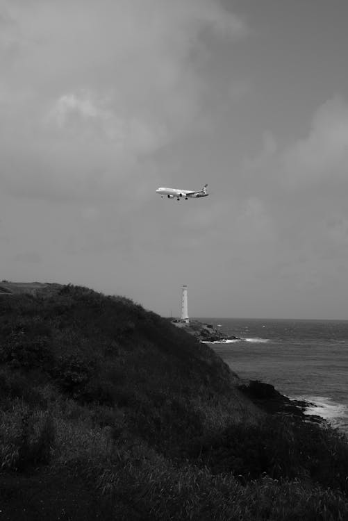 Airplane Flying over Lighthouse · Free Stock Photo