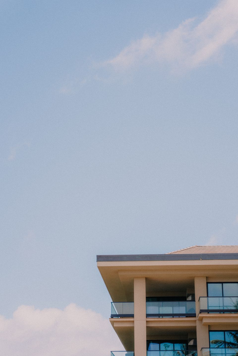 The top floor and balcony of a building against a pale sky