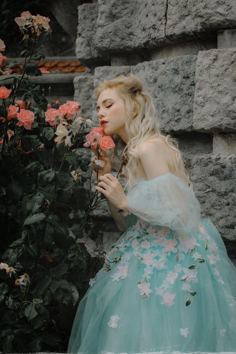 Blonde Girl In Dress Posing Near Flowers