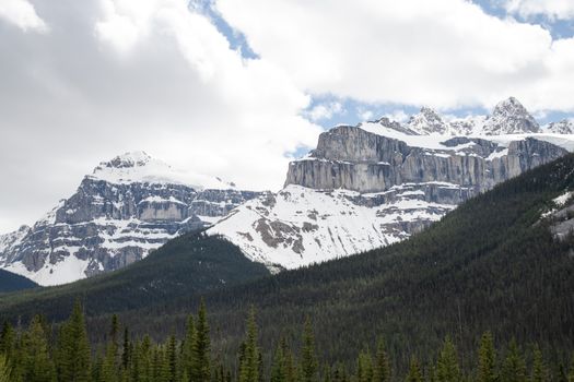 Breathtaking snow-covered Castle Mountain under a cloudy sky in Alberta, Canada.