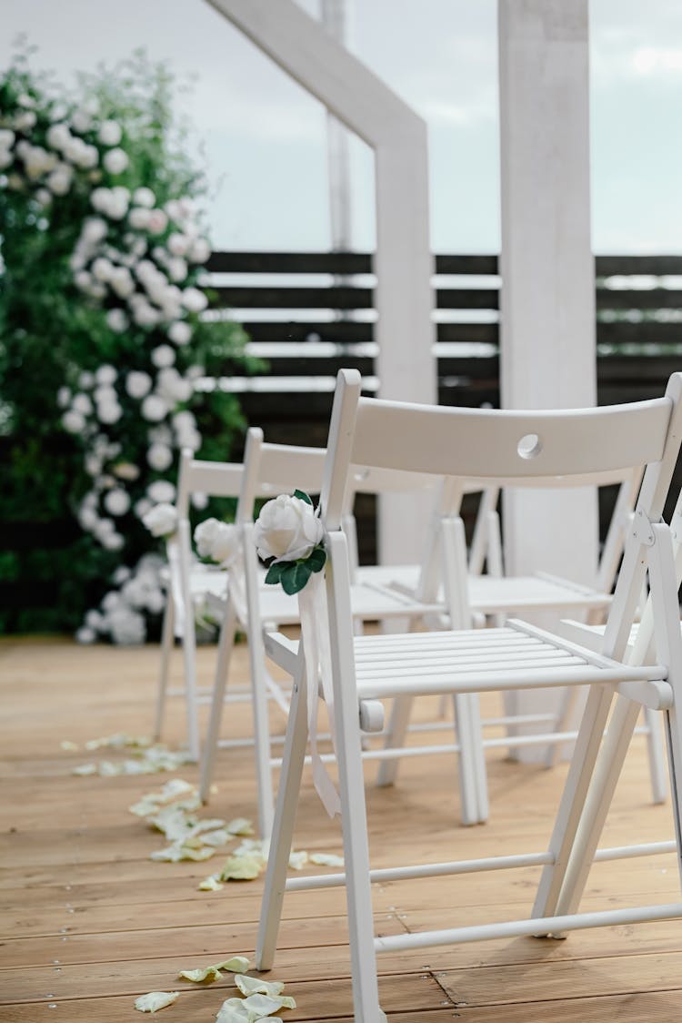 White Chairs With Flowers For Wedding Party