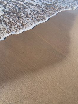 Peaceful beach scene with gentle waves lapping on the sandy shore, capturing the essence of coastal tranquility.