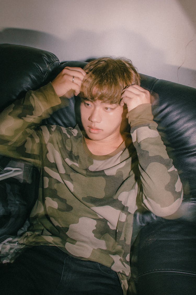 Young Man Sitting On Leather Couch