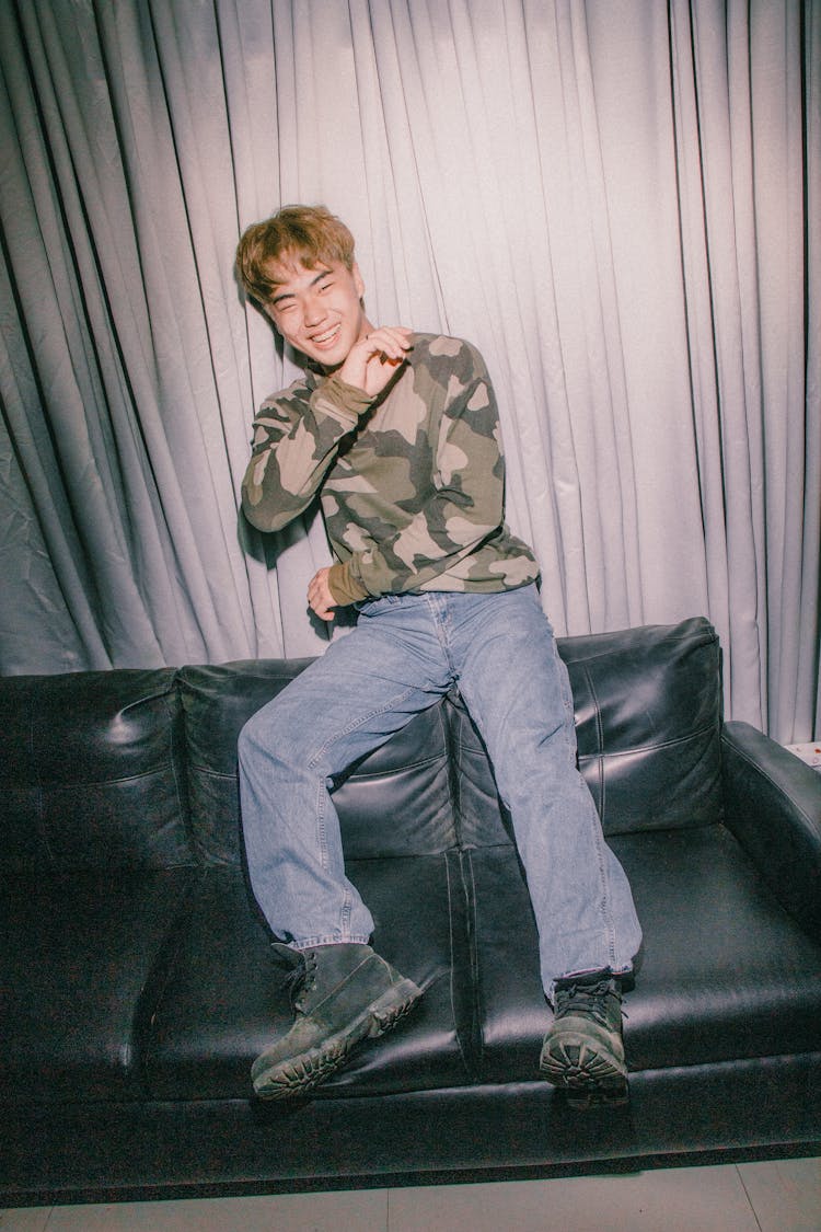 Portrait Of Smiling Man Sitting On Leather Couch