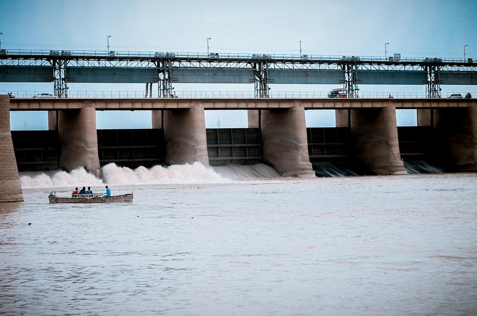 Hydroelectric dam in Jamshoro, Sindh with boat and people on Indus River.