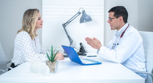 Doctor Talking with Woman in White Long Sleeve Shirt