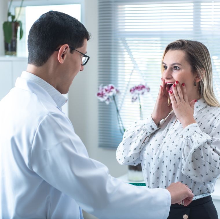 Woman surprised by results in a medical consultation with doctor measuring her waist.
