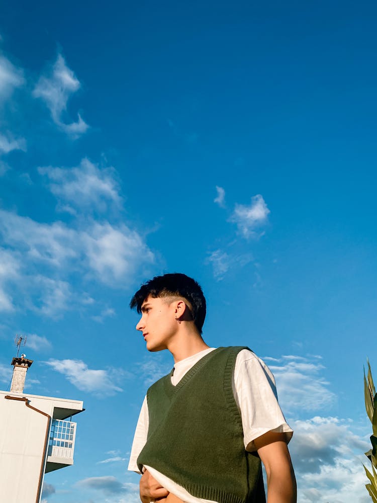 Young Man Posing On Blue Sky Background