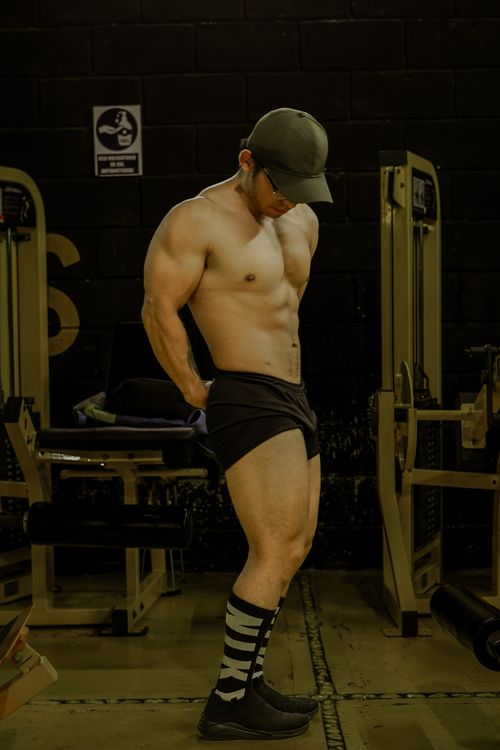 Free Muscular man posing in a gym, showcasing strength and fitness. Stock Photo