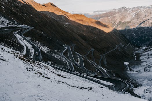 Scenic winter view of Stelvio Pass winding through snow-covered mountains in the Italian Alps.