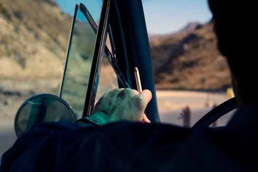 Driving through Iran's scenic landscapes in a classic car, holding a cigarette.