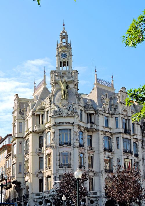Free Ornate architectural landmark with a clock tower in a sunny urban setting in Porto, Portugal. Stock Photo