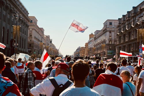 People Walking on Street Holding Flags in Protest