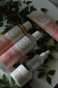 A stylish flat lay of skincare products surrounded by fresh greenery, ideal for beauty and wellness themes.