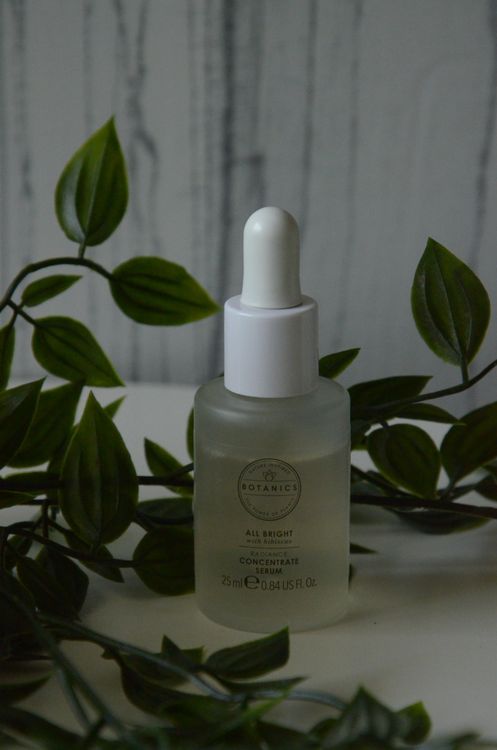 Close-up of a skincare serum dropper bottle in a botanical setting