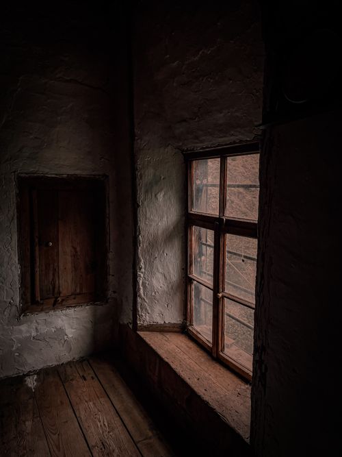 Free Dark and atmospheric view of a wooden window and wall in an old house corner. Stock Photo