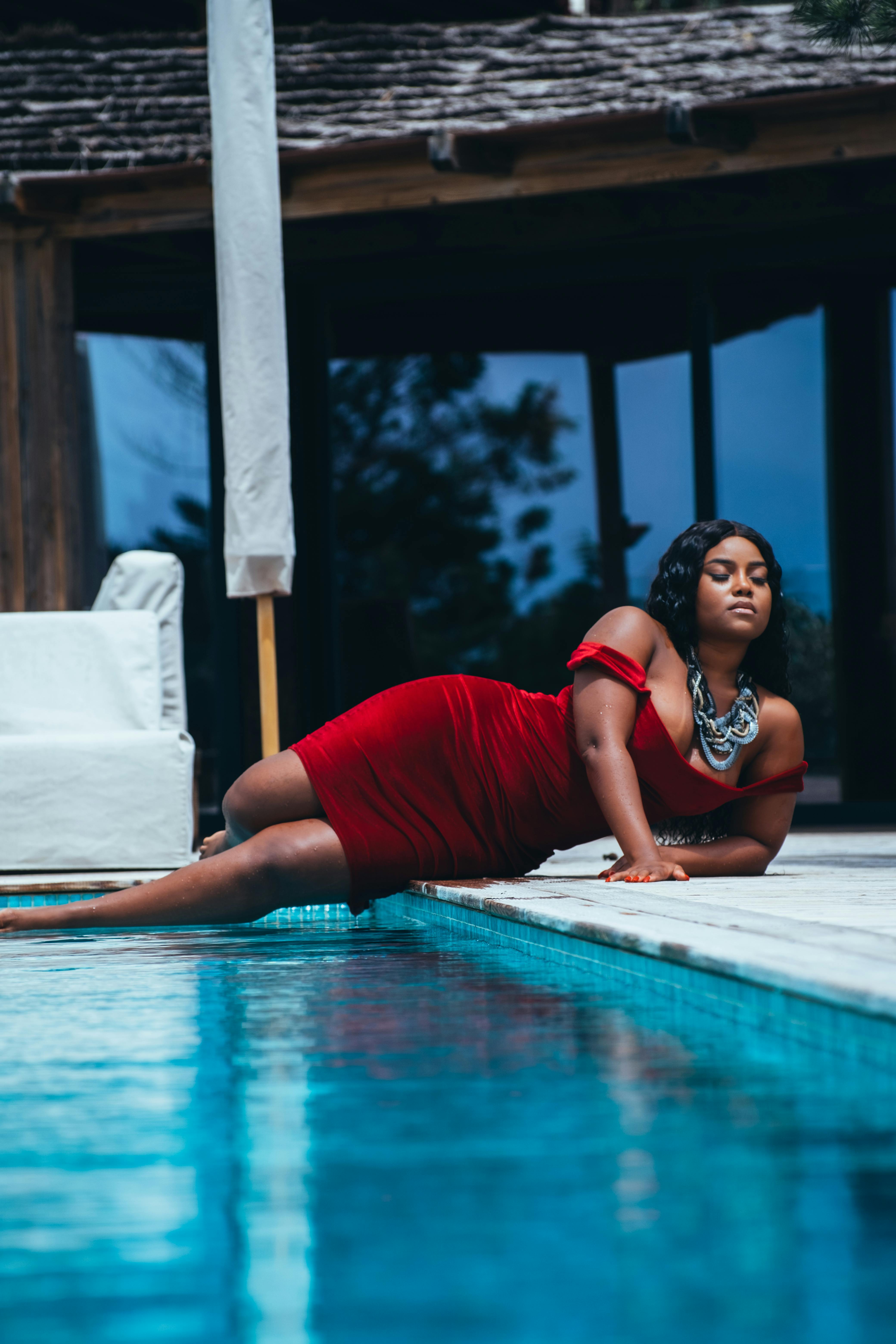 Woman in a Red Dress Getting Out of a Swimming Pool · Free Stock Photo