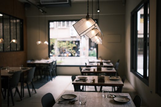 Modern restaurant interior featuring stylish hanging lights and neatly arranged tables.