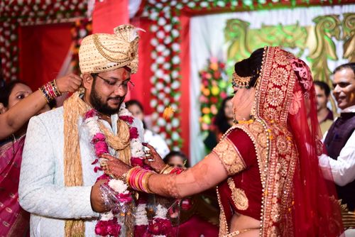 Free A vibrant scene capturing a traditional Indian wedding ceremony with bride and groom exchanging garlands. Stock Photo