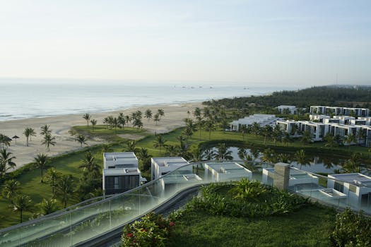 Scenic view of modern beachfront villas and lush greenery overlooking the ocean.