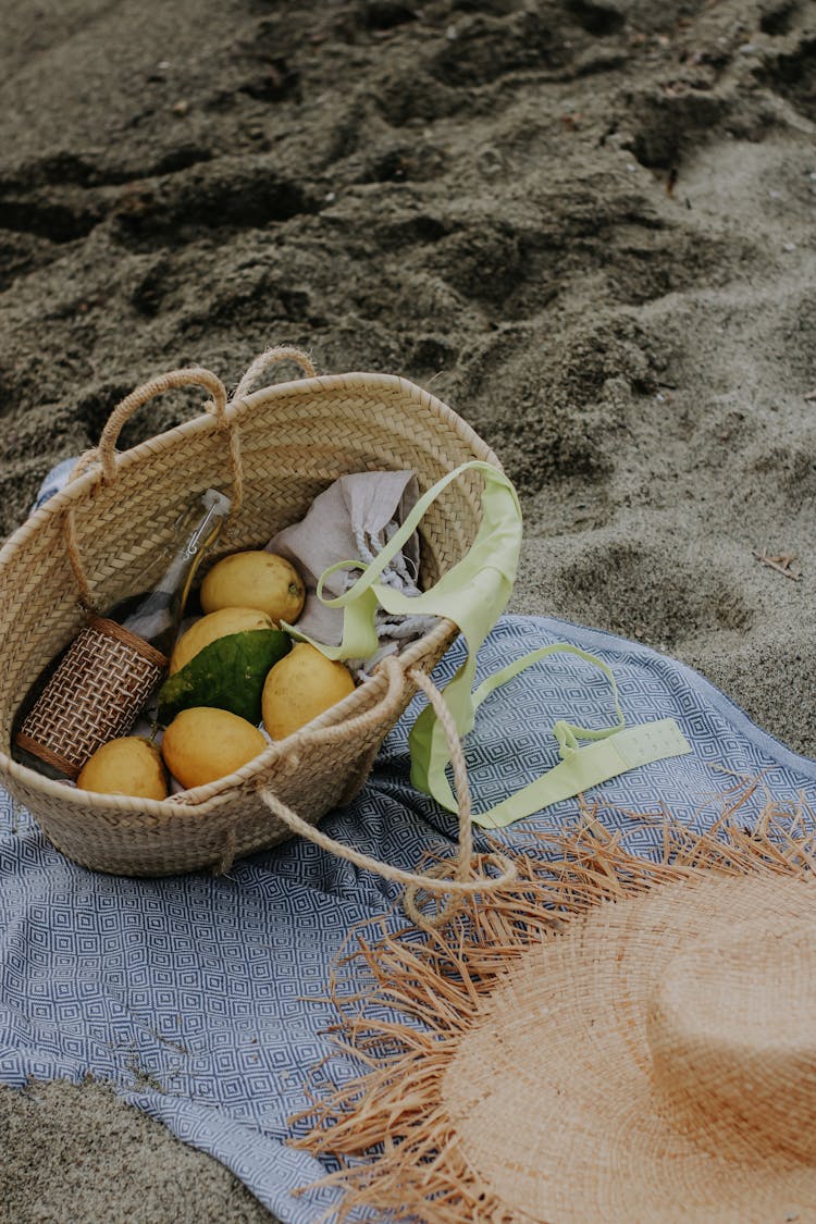 Fruit And Bottle In Basket On Sand