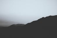A Silhouette of Mountains under a Cloudy Sky