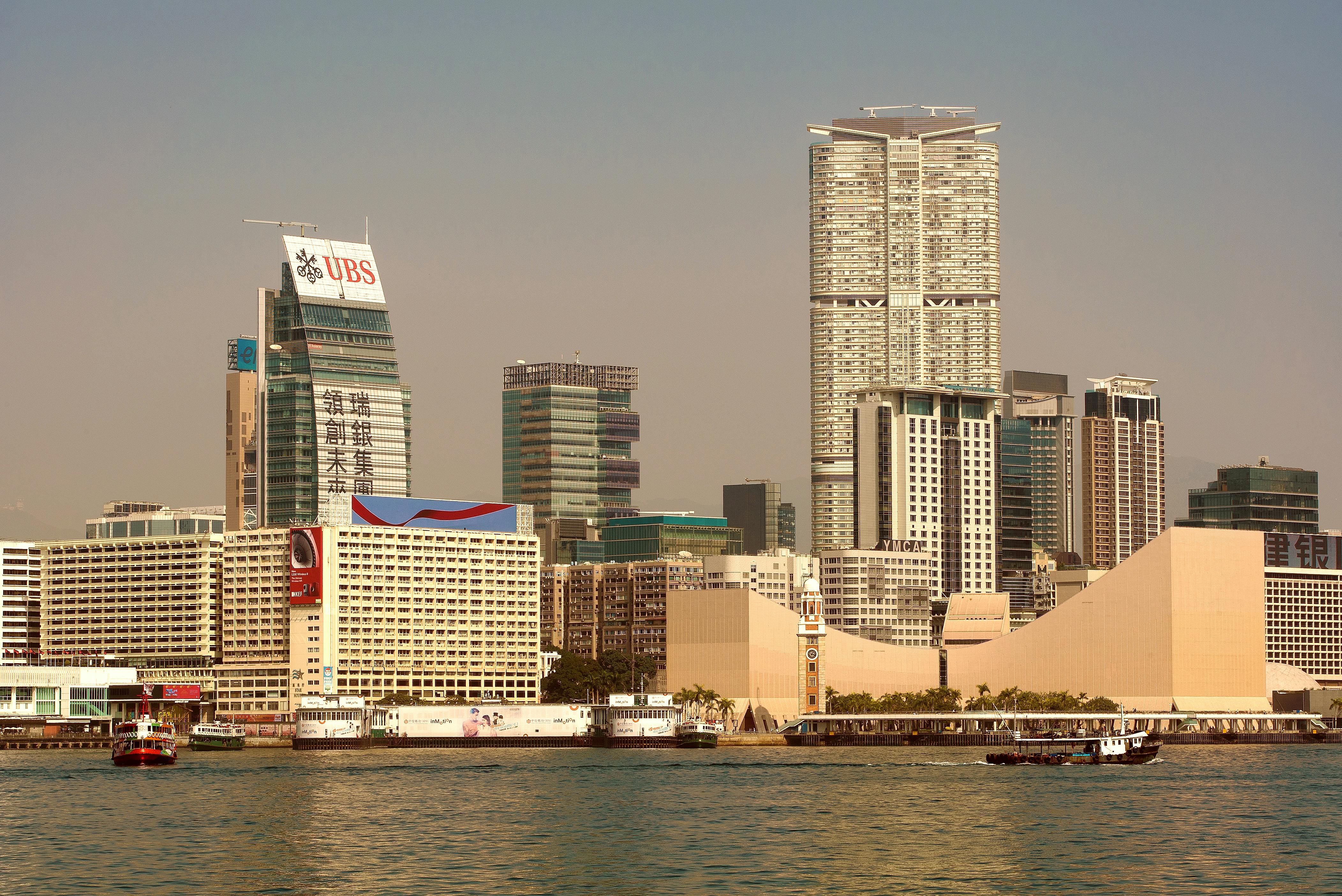 Explore the dynamic skyline of Hong Kong with towering skyscrapers and bustling waterfront activity.