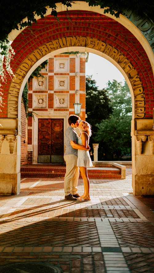 Couple Standing under Arch Kissing