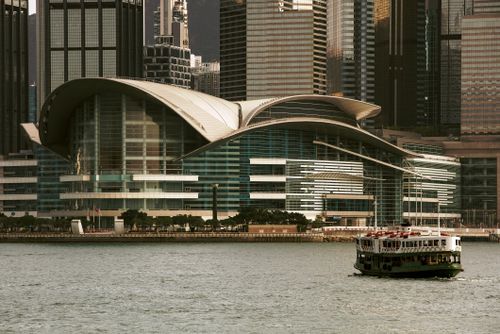 Free View of ferry near Hong Kong Convention Center with city skyline backdrop. Stock Photo
