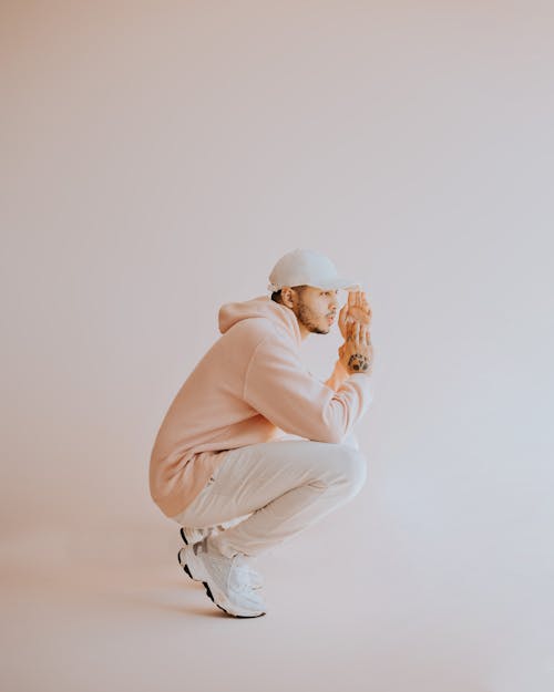 Man in Cap and Hoodie Crouching