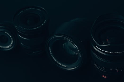 Close-up of multiple camera lenses in a dimly lit setting, emphasizing technology.