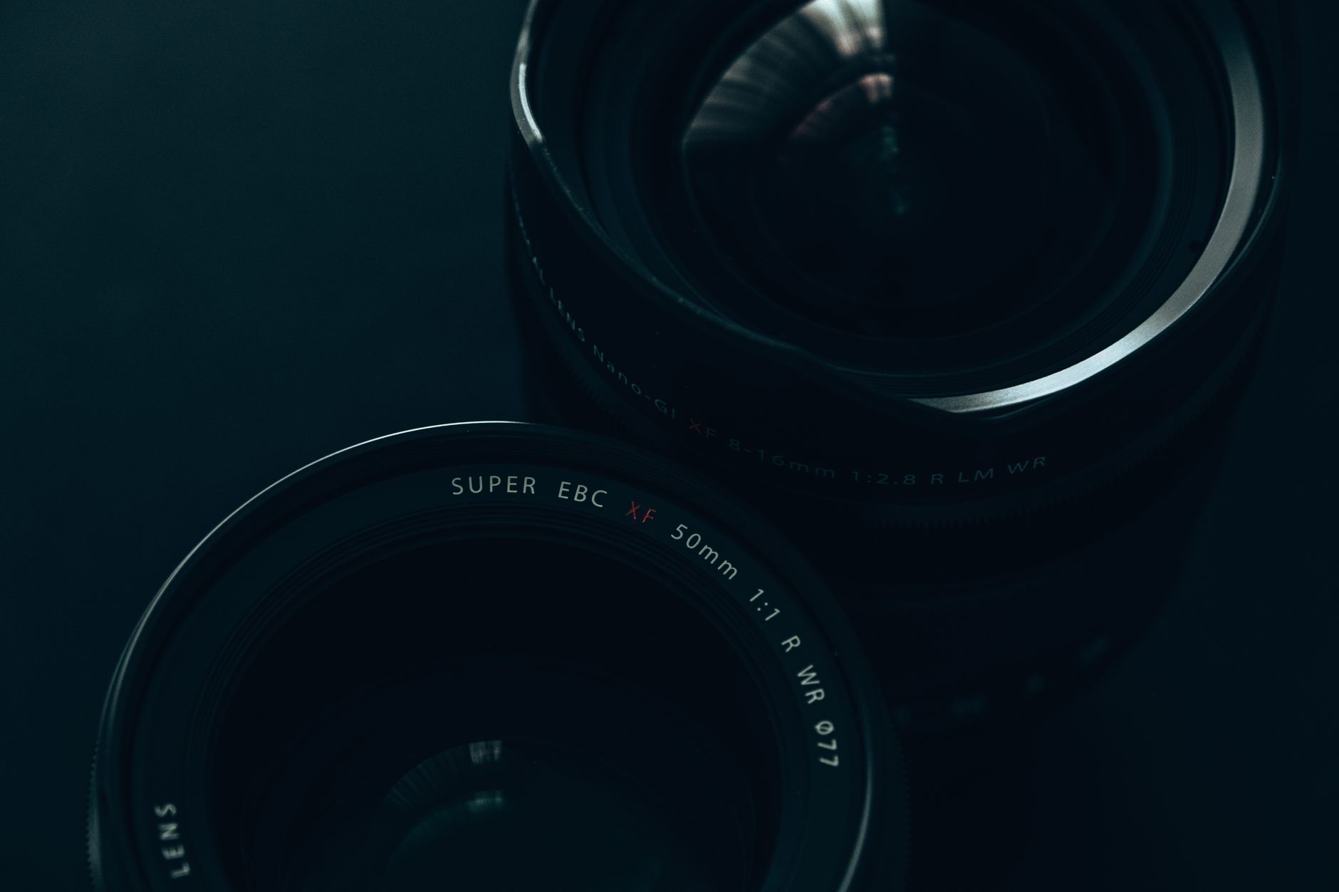 Artistic close-up of camera lenses, highlighting reflective surfaces and intricate design details.