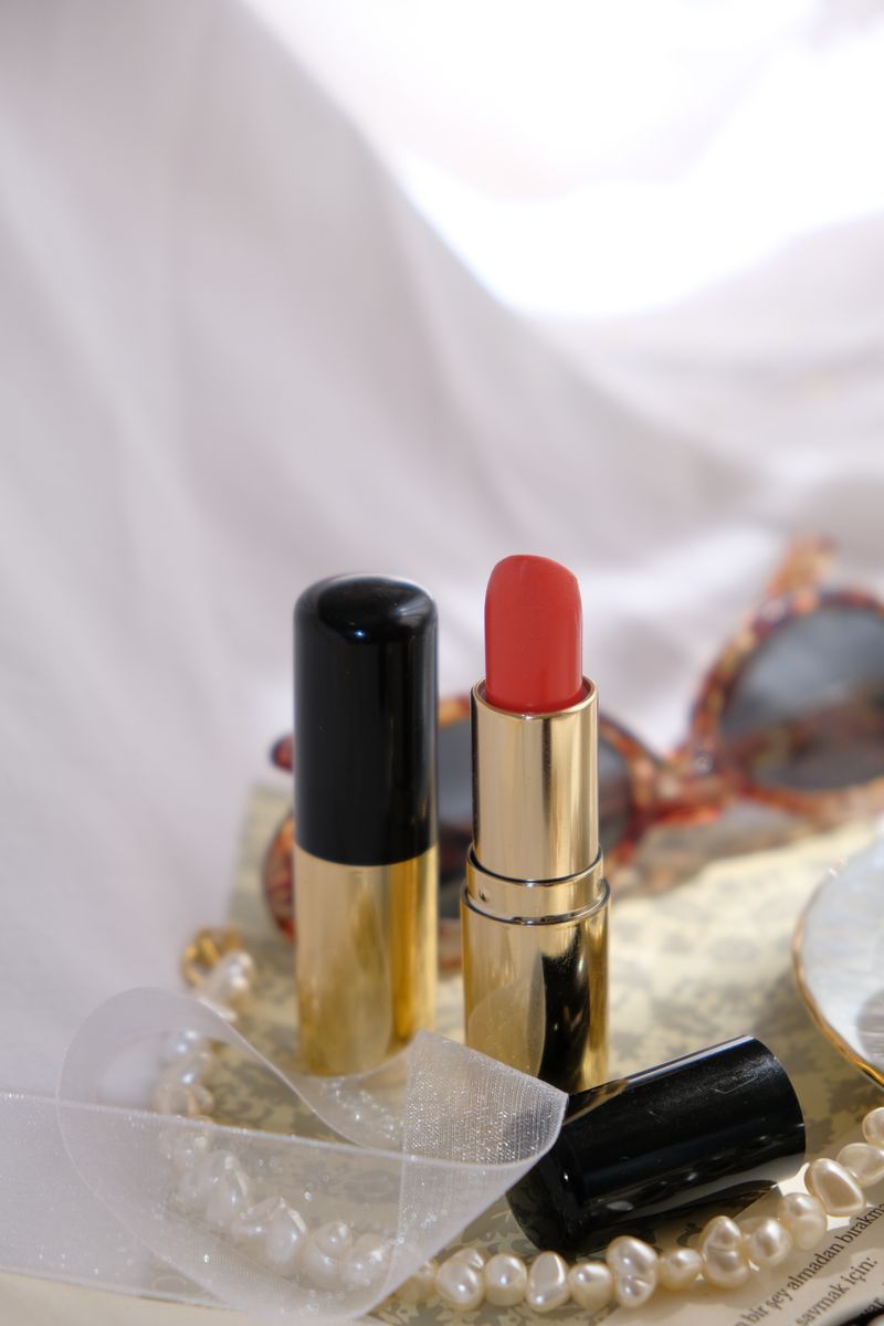 A tinted lip balm in a brass case resting on soft fabric