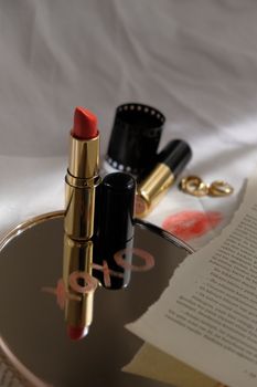 Close-up of a red lipstick, mirror reflection with 'XOXO', enhancing beauty and style.