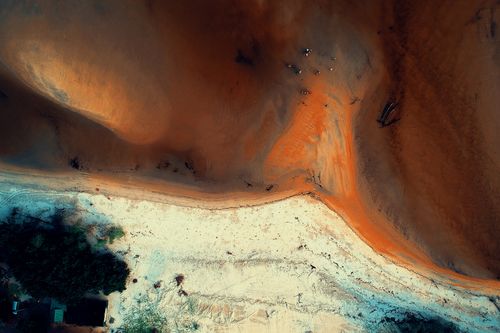 Free Stunning aerial view capturing contrasting sand and water hues along a beautiful beach. Stock Photo