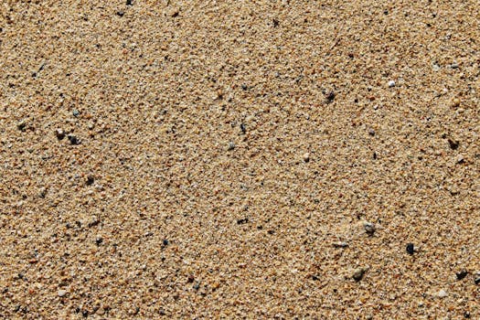 沙滩表面的特写详细地显示了纹理和微小的鹅卵石